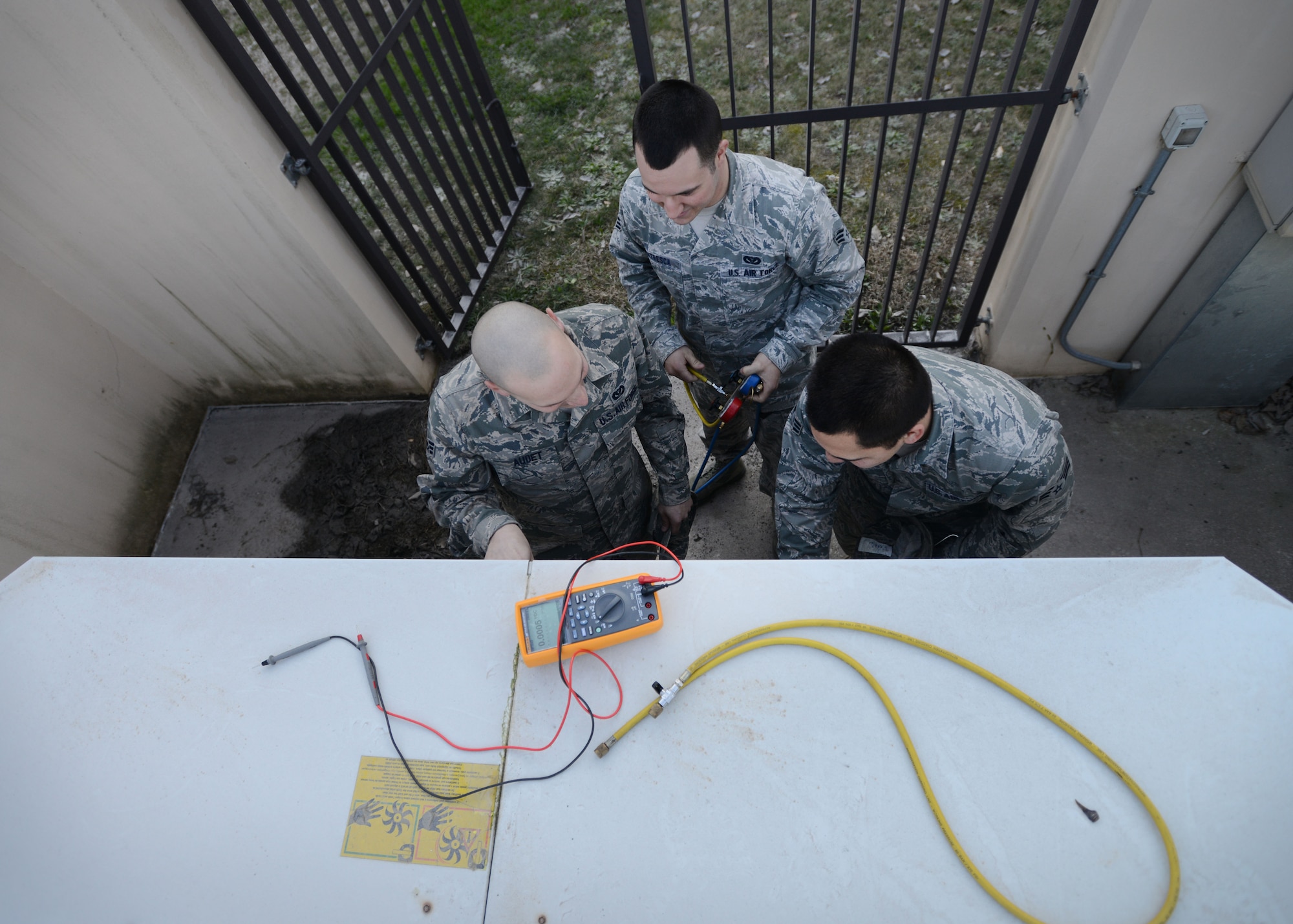 (From left) Senior Airmen Michael Audet, Justin Peredo and Matthew Ventresca, 31st Civil Engineer Squadron heating, ventilation, air conditioning and refrigeration technicians, inspect an AC unit outside the dormitories, Feb 24, 2014, at Aviano Air Base, Italy. Maintaining comfortable living arrangement for the dormitories is just one part the HVAC/R teams are responsible for, which contributes to positive living conditions. (U.S. Air Force photo/Airmen 1st Class Deana Heitzman)  