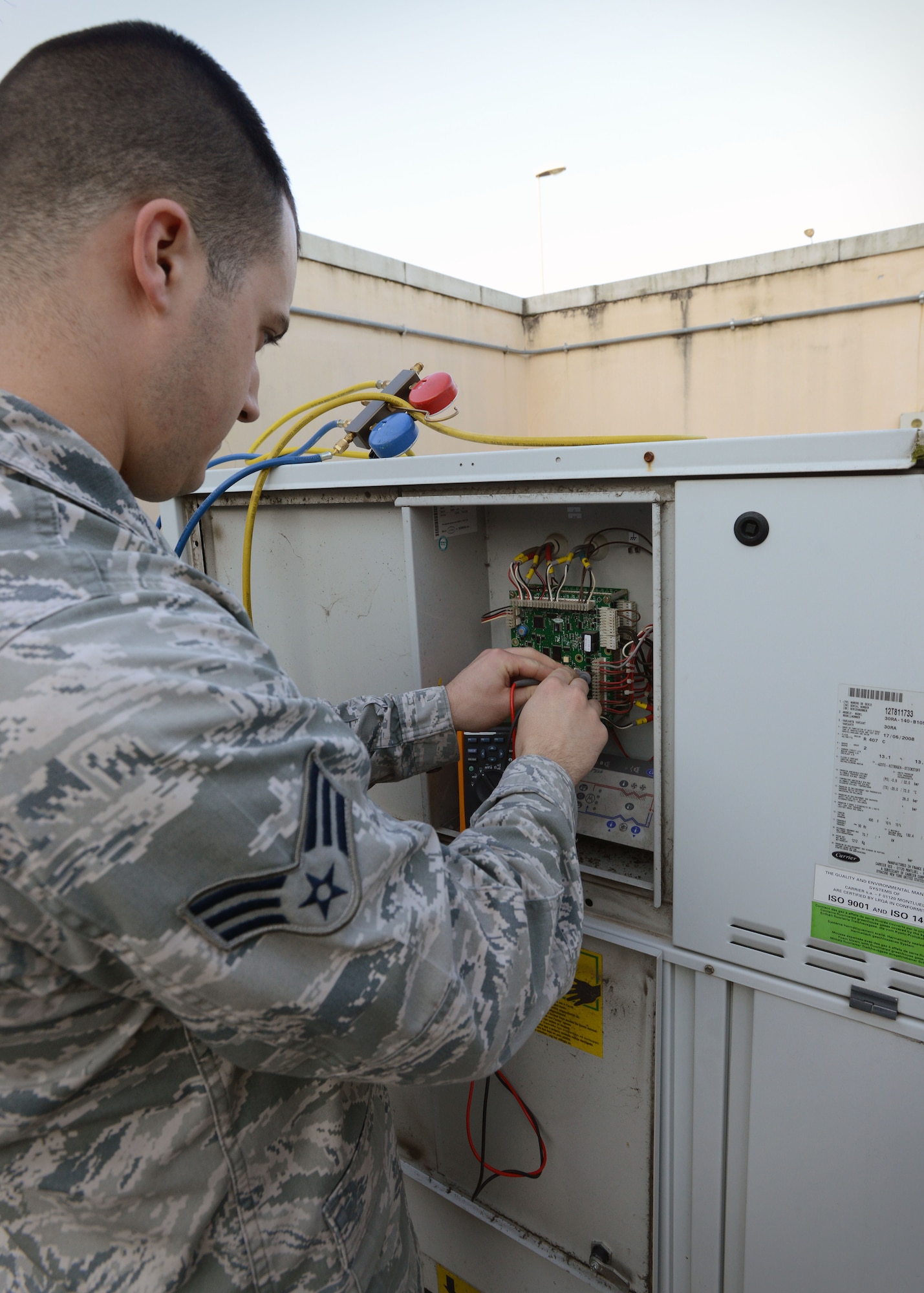 Senior Airman Matthew Ventresca, 31st Civil Engineer Squadron heating, ventilation, air conditioning and refrigeration technician, resets a circuit board on an AC unit, Feb 24, 2014, at Aviano Air Base, Italy.  The board provides HVAC/R technicians the working status of AC units and any known warning signs or problems. (U.S. Air Force photo/Airman 1st Class Deana Heitzman)  