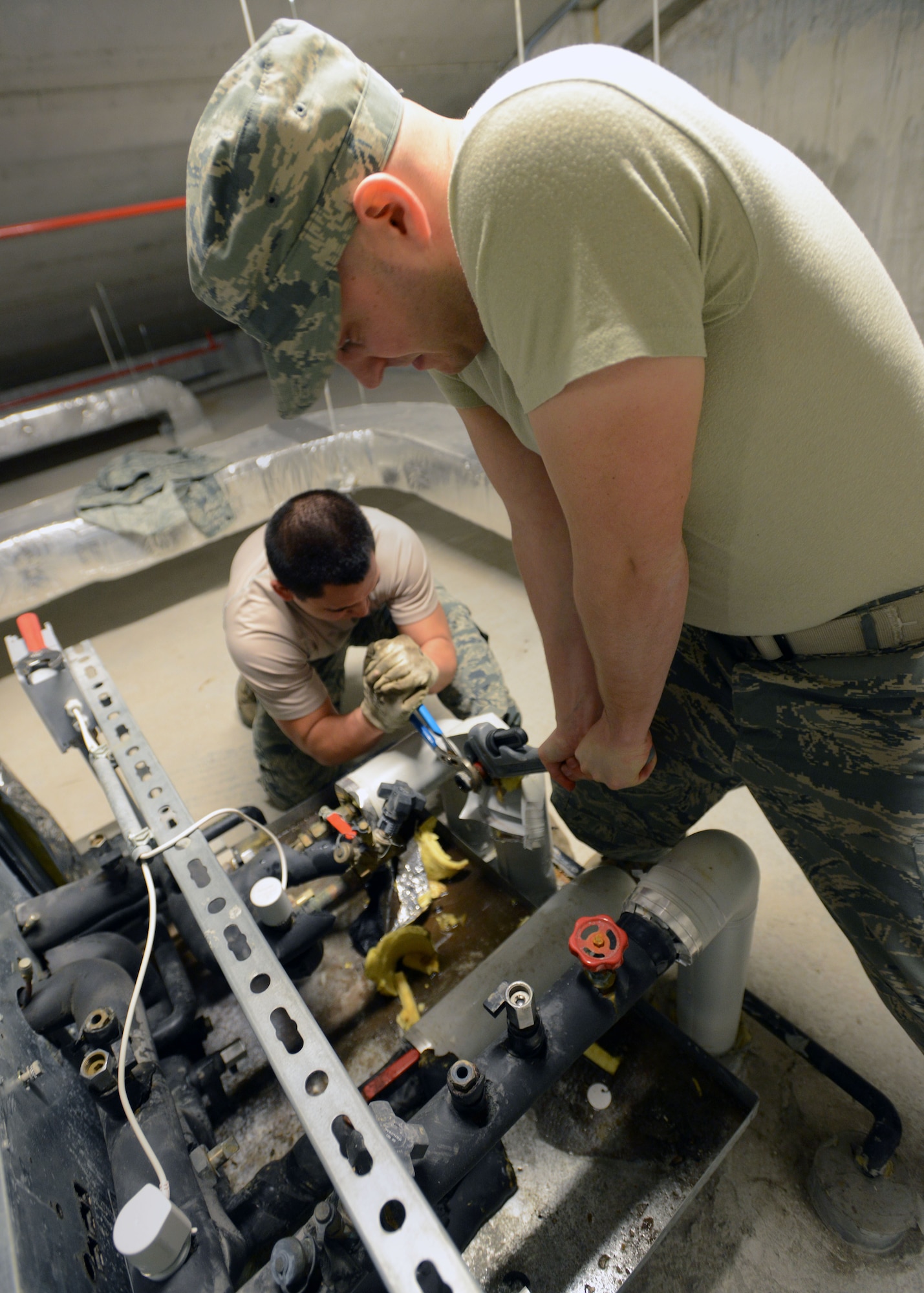 (From left) Senior Airmen Justin Peredo and Michael Audet, 31st Civil Engineer Squadron heating, ventilation, air conditioning and refrigeration technicians, loosen a bolt on a pipe, Feb 24, 2014, at Aviano Air Base, Italy. The HVAC/R team receives 20 to 30 work orders daily, ranging from lack of hot water to rare emergency requests. (U.S. Air Force photo/Airman 1st Class Deana Heitzman)  