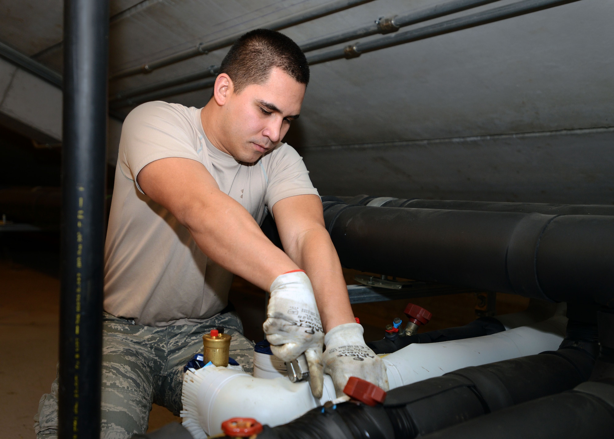 Senior Airman Justin Peredo, 31st Civil Engineer Squadron heating, ventilation, air conditioning and refrigeration technician, cuts tubing around a pipe, Feb. 19, 2014, at Aviano Air Base, Italy. HVAC/R technicians maintain the hot water supplied to dormitories, dining facilities and fitness centers.  (U.S. Air Force photo/Airman 1st Class Deana Heitzman)
