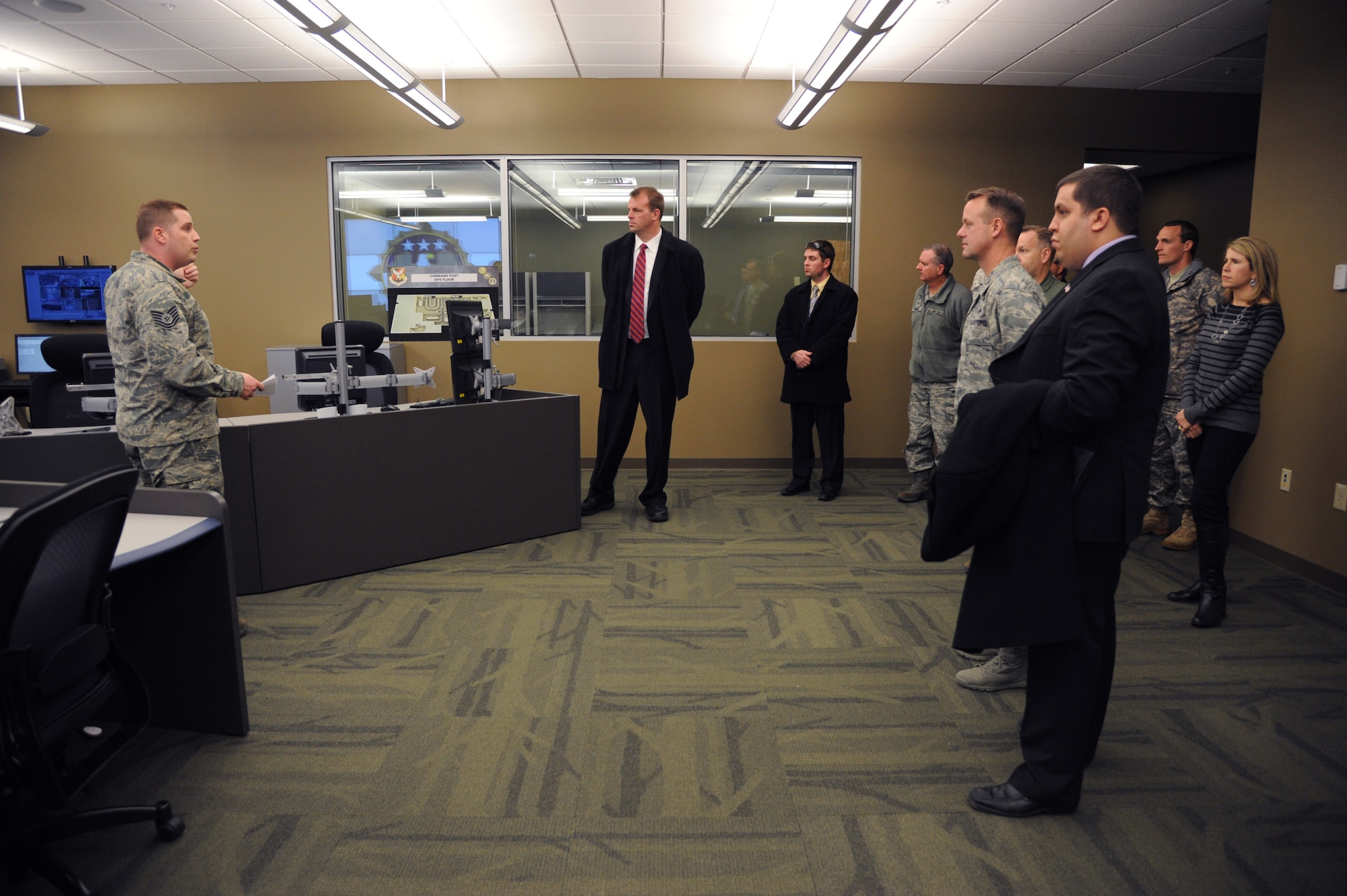 Tech. Sgt. Jeremy Bixel, Joint Base McGuire-Dix-Lakehurst Command Post controller, speaks to distinguished visitors and JB MDL leaders during a tour of the JB MDL Command Post and 305th Operations Support Squadron new joint facility Feb. 24, 2014, at JB MDL, N.J. The new facility attributes to increased mission effectiveness for the JB MDL Command Post by increasing its command and control capabilities through upgrades in technology and a larger facility to operate in. (U.S. Air Force photo by Airman 1st Class Sean M. Crowe/Released)