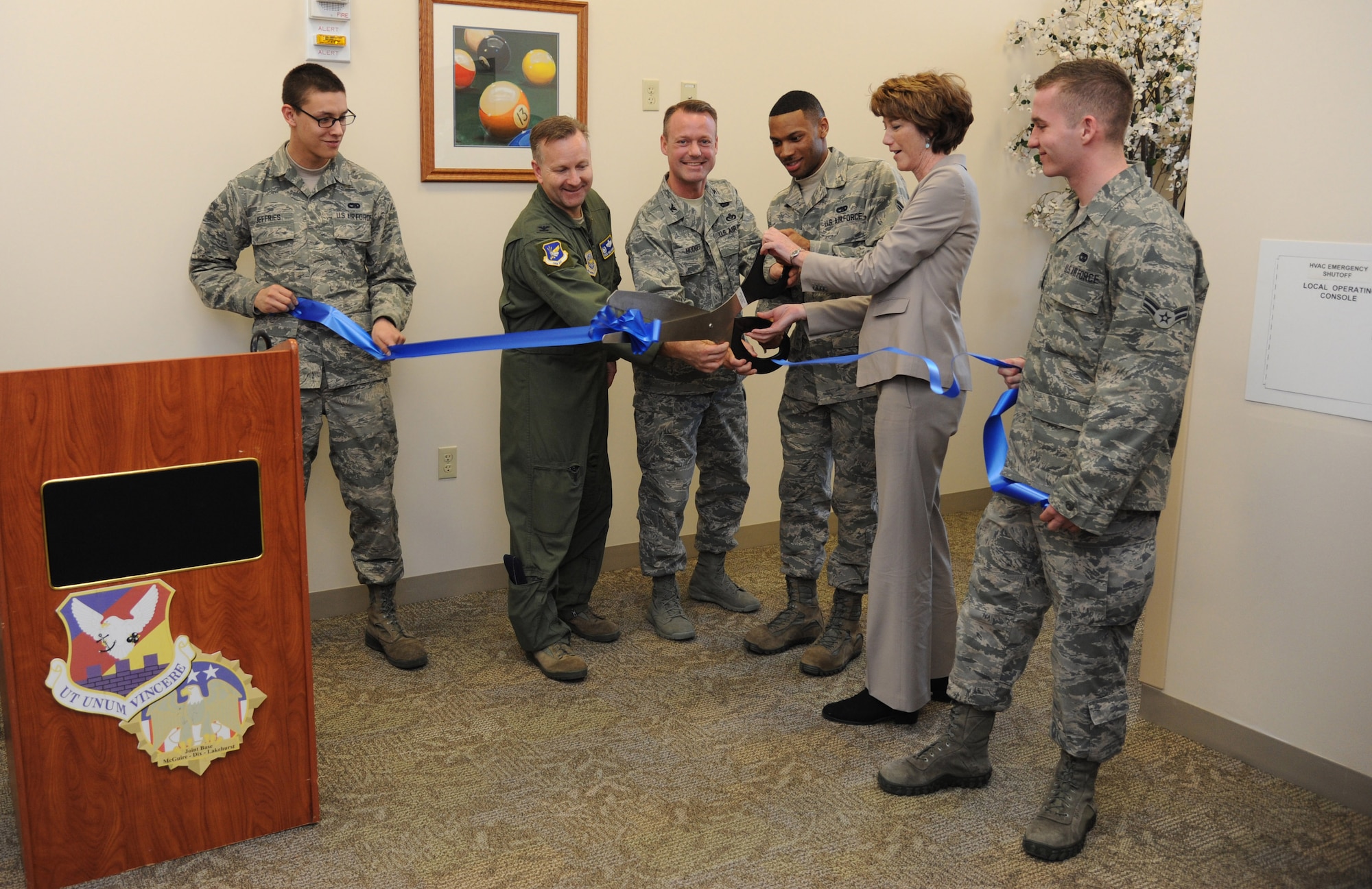 Second from left, Col. Richard Williamson, 305th Air Mobility Wing commander; Col. James Hodges, Joint Base McGuire-Dix-Lakehurst and 87th Air Base Wing commander; Airman 1st Class Damien Cook, 305th Aerial Port Squadron member, and Kathleen Ferguson, acting Assistant Secretary of the Air Force for Installations, Environment and logistics, cut a ceremonial ribbon to signify the opening of a new dormitory Feb. 24, 2014, at JB MDL, N.J. The new dormitory replaced two demolished dormitories at JB MDL and improved the quality of life for its tenant service members. (U.S. Air Force photo by Airman 1st Class Sean M. Crowe/Released)