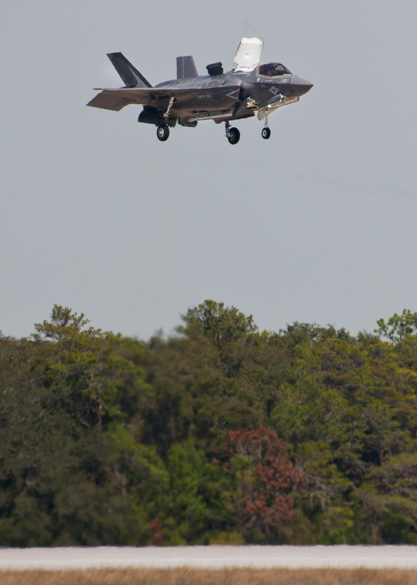 Royal Air Force pilot, Squadron Leader Hugh Nichols, hovers over the landing pad in a Marine F-35B Lightning II during the first short take-off and vertical landing sortie by a United Kingdom pilot at Eglin Air Force Base, Fla., Feb. 25.  The U.S. Marines began flying STOVL sorties at Eglin in October 2013.  (U.S. Air Force photo/Samuel King Jr.)