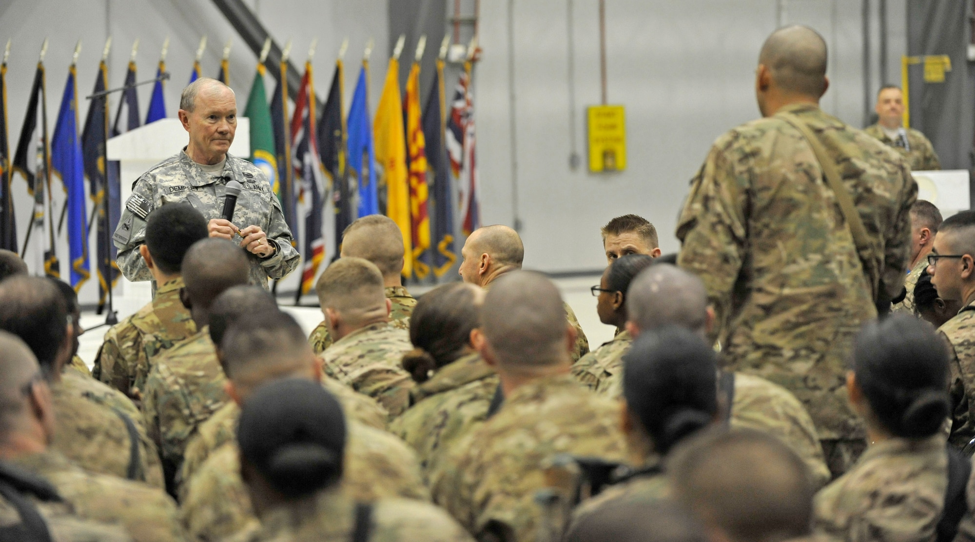 U.S. Army Gen. Martin E. Dempsey, chairman of the Joint Chiefs of Staff, fields a question from a Service member at Bagram Airfield, Afghanistan, Feb. 26, 2014. Dempsey hosted a town hall meeting where he answered questions ranging from the future of U.S. military operations in Afghanistan to force reduction measures.(U.S. Air Force photo by Senior Master Sgt. Gary J. Rihn/Released)(photo was cropped to emphasize subject)