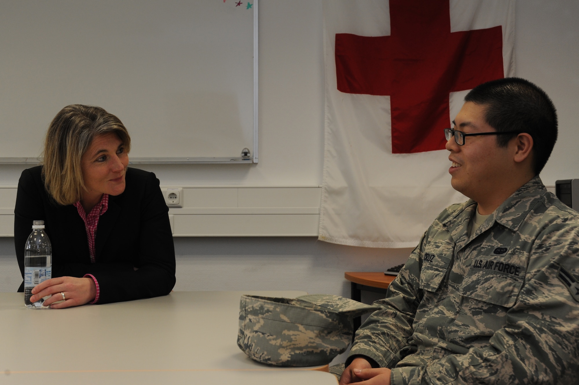 Sherri Brown, senior vice president of the American Red Cross' Service to the Armed Forces, visits with U.S. Air Force Airman 1st Class JanMichael Cruz, 52nd Fighter Wing command section executive administrator and Red Cross volunteer, Feb. 25, 2014 at Spangdahlem Air Base, Germany. Brown visited with Red Cross volunteers at a lunch during her tour. (U.S. Air Force photo by Airman 1st Class Dylan Nuckolls/Released)