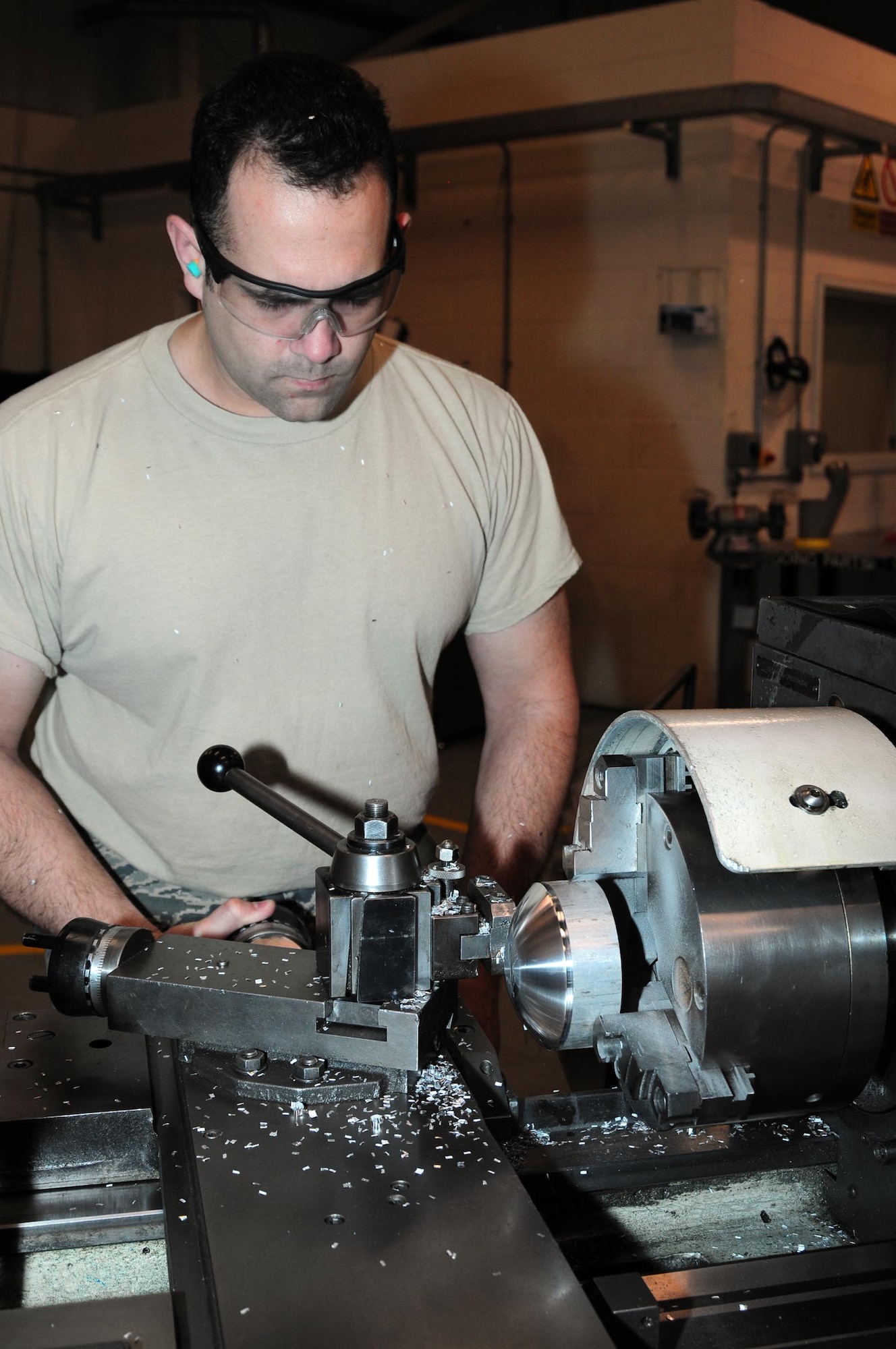 U.S. Air Force Tech. Sgt. Israel Caballero, 100th Maintenance Squadron Aircraft Metals Technology craftsman from Palmdale, Calif., parts off a thread protector for support equipment Feb. 17, 2014, in Hangar 814 on RAF Mildenhall, England. Aircraft Metals Technology Airmen make many metal parts for aircraft and equipment from scratch. The entire process for making the thread protector took approximately four hours and included internal drilling, threading, radiusing on the metal piece, then parting off the required section. (U.S. Air Force photo by Karen Abeyasekere/Released)