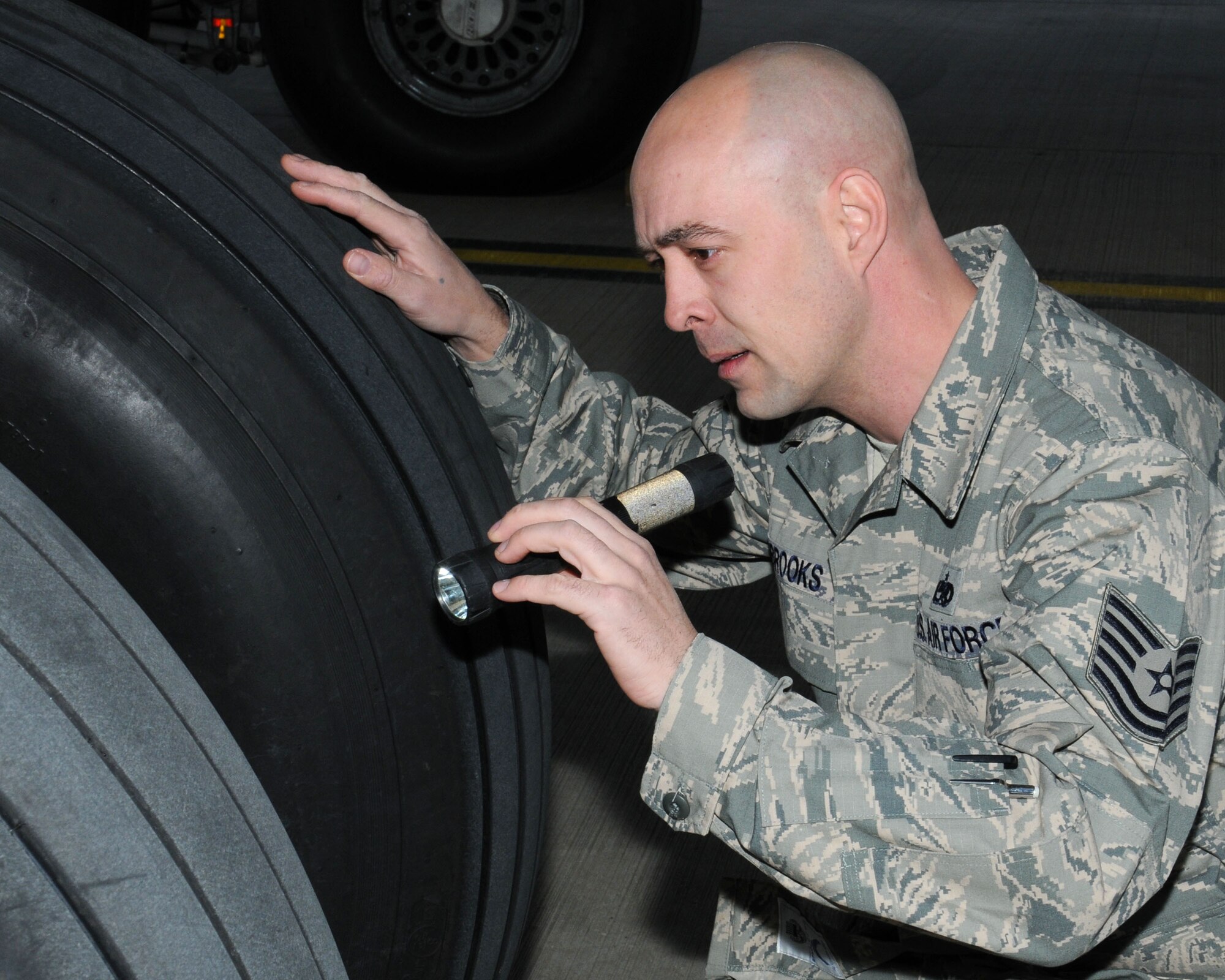 U.S. Air Force Tech. Sgt. Shannon Brooks, 100th Aircraft Maintenance Squadron production expeditor from Folio, Calif., performs an aircraft preflight inspection on a KC-135 Stratotanker Feb. 19, 2014, on RAF Mildenhall, England. Brooks improved the wash rack program by establishing a team structure, ensuring the wash teams had transportation and adequate tools, and he implemented a 30-day wash cycle. (U.S. Air Force photo by Gina Randall/Released)