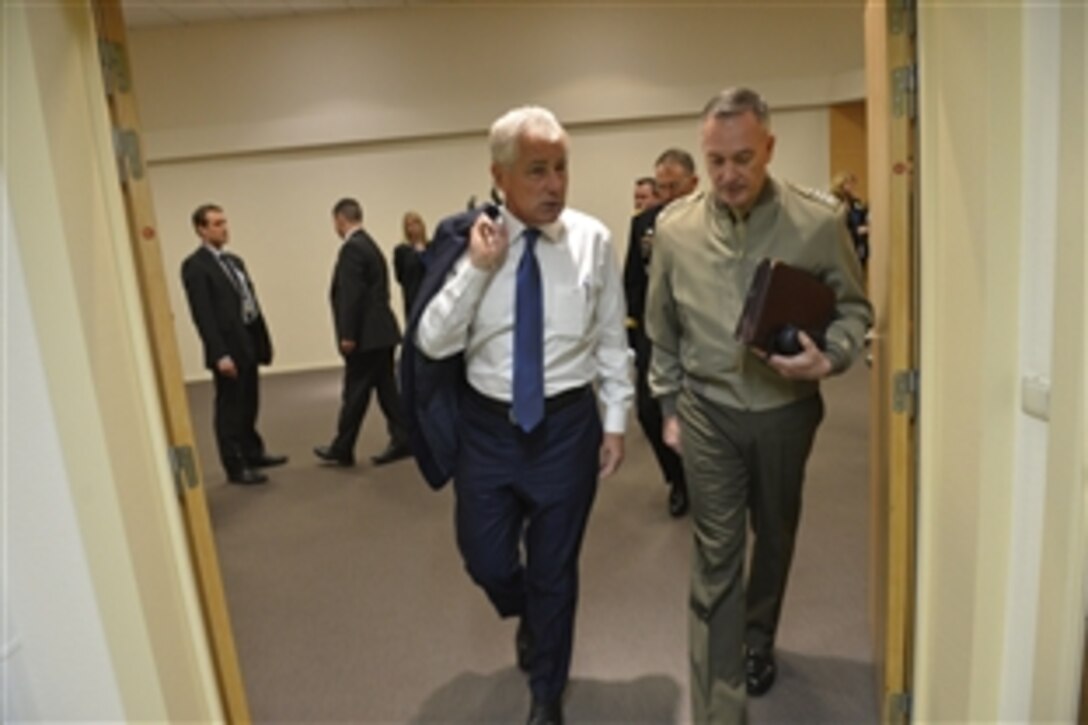 U.S. Defense Secretary Chuck Hagel, left, walks with U.S. Marine Corps Gen. Joseph F. Dunford Jr., commander of the International Security Assistance Force in Afghanistan, while attending a NATO defense ministerial meeting in Brussels, Feb. 26, 2014.