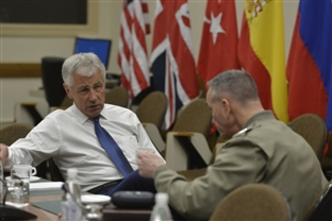 U.S. Defense Secretary Chuck Hagel, left, meets with U.S. Marine Corps Gen. Joseph F. Dunford Jr., commander of the International Security Assistance Force in Afghanistan, while attending a NATO defense ministerial meeting in Brussels, Feb. 26, 2014.