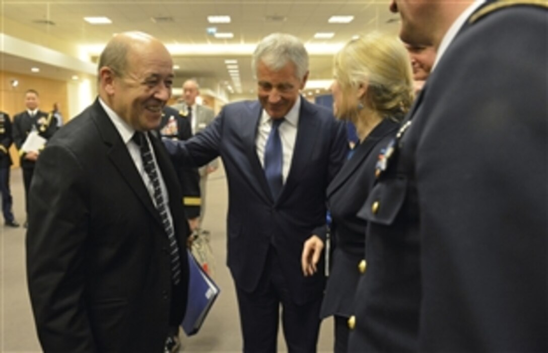 U.S. Defense Secretary Chuck Hagel meets briefly with French Defense Minister Jean-Yves Le Drian as he attends the meetings for NATO defense ministers in Brussels, Feb. 26, 2014.