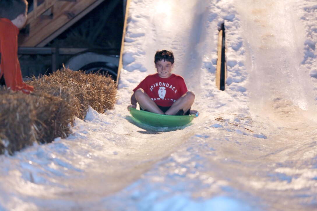 A child slides down the icy slopes at the Snow Up The Park event at the Swansboro Municipal Park, Feb. 21. The event was the first of its kind for the local area and consisted of sledding, arts and crafts, face painting, a live DJ and freshly made snow.