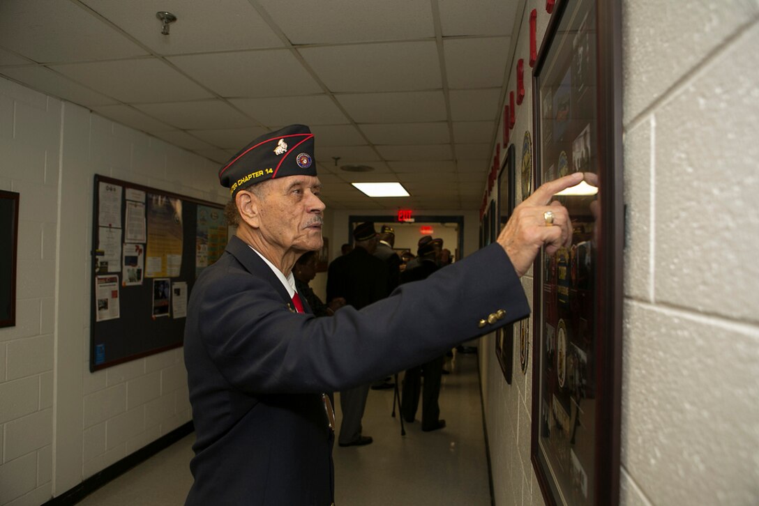 Master Gunnery Sergeant (retired) Jimmy Hargove of the Montford Point Marines Association looks over one of the displays at the dedication ceremony for the new Montford Point Marines Memorial wall at the Center for Naval Aviation Technical Training Unit aboard Naval Air Station Oceana, Va 21 February, 2014. The memorial wall is dedicated to the service of the Montford Point Marines who in 1941 were the first African Americans to join the U.S. Marine Corps.