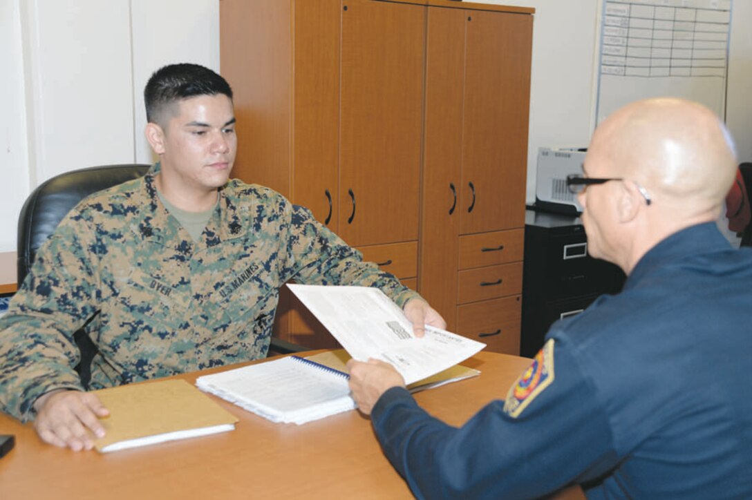 Sgt. Thomas Over, volunteer income tax assistant, Tax Center noncommissioned officer, Marine Corps Logistics Base Albany, prepares taxes for Marine Corps Police Department Deputy Police Chief Sean Lamonzs at the Tax Center in Building 3500, recently.