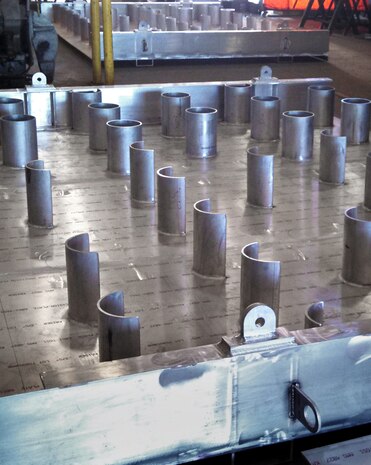 During a mid-point inspection Jan. 15 at a fabrication facility in Longview, Wash., Corps engineers checked out an arrangement of baffles welded into the floor of a one-foot-high box-like section. The circle and half-circle baffles create a variety of flow velocities for lampreys entering the fish ladder. Future studies will help researchers determine which velocities are most preferred by migrating lampreys.