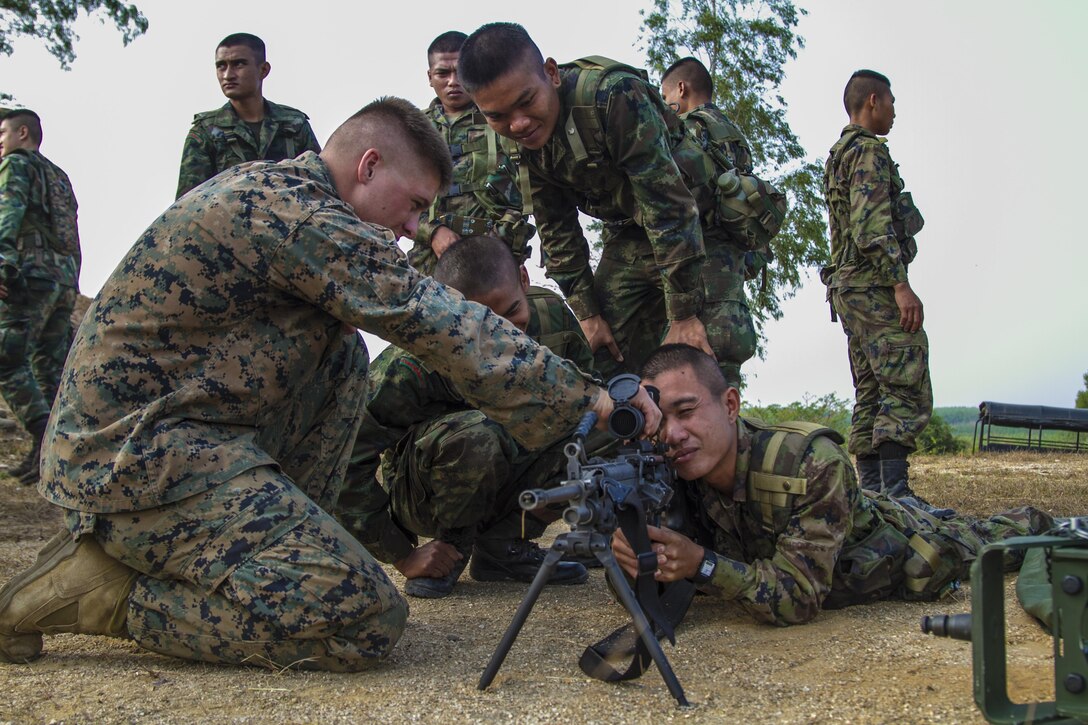 Lance Cpl. Mitch Schenk, a Harrisburg, S.D. native, shows the effects of light on the standard issue optic attached to the M249 squad automatic weapon to a group of Royal Thai Marines Feb. 12 at Ban Chan Krem, Kingdom of Thailand during Exercise Cobra Gold. Cobra Gold, in its 33rd iteration, is designed to advance regional security by exercising a robust multinational force from nations sharing common goals and security commitments in the Asia-Pacific region. The Thai Marines are with 3rd Company, 7th Battalion, Royal Thai Marine Corps. Schenk is a machine-gunner with Weapons Company, 3rd Battalion, 1st Marine Regiment currently assigned to 4th Marine Regiment, 3rd Marine Division, III Marine Expeditionary Force under the unit deployment program.
