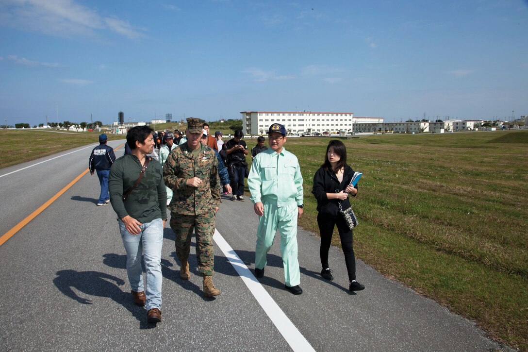 Mayor Atsushi Sakima, second from the right, talks with Col. James G. Flynn, second from the left, Feb. 22 at Marine Corps Air Station Futenma during a tsunami evacuation drill. Both men were integral in completing a disaster response agreement during late 2013 on an evacuation strategy allowing local residents to move to higher ground. Flynn is the commanding officer of Marine Corps Air Station Futenma, Marine Corps Installations Pacific. (U.S. Marine Corps photo by Lance Cpl. Pete Sanders/Released)