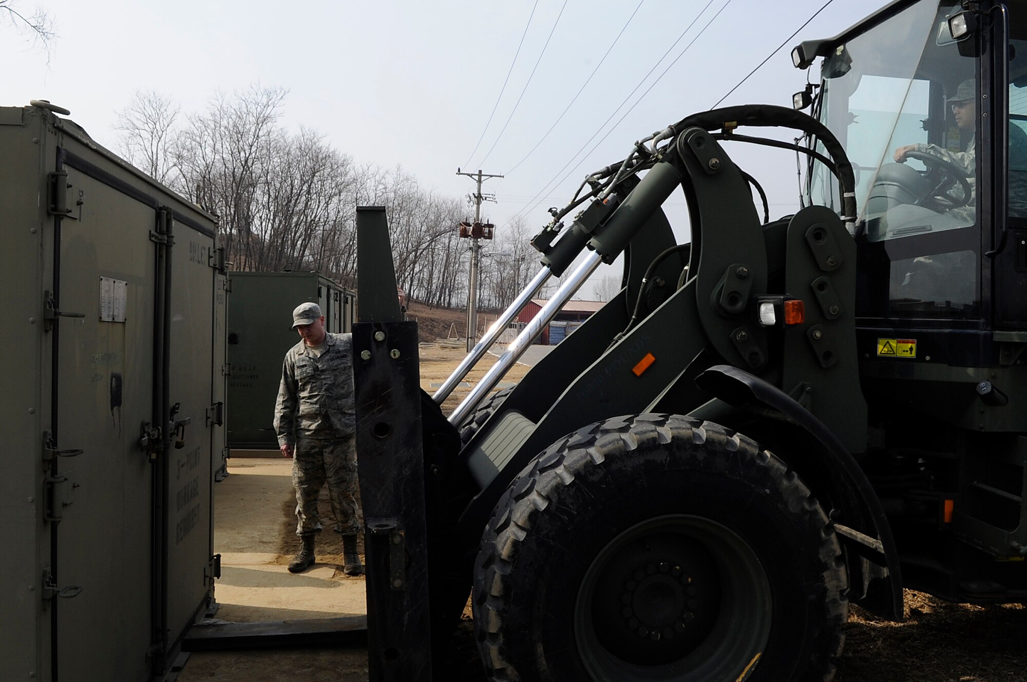 U.S. Air Force Senior Airman Matthew Fehrman, 35th Civil Engineer Squadron heavy equipment repair journeyman, from Misawa Air Base, Japan, guides a forklift to pick up a container of spare parts during Exercise Key Resolve 2014 at Osan Air Base, Republic of Korea, Feb. 27, 2014. The 35 CES is responsible for maintaining more than 65 Environmental Control Units, 23 tents, two K-Spans, 12 storage containers and three latrines for augmentees during the exercise. (U.S. Air Force photos/Senior Airman Marcus Morris)