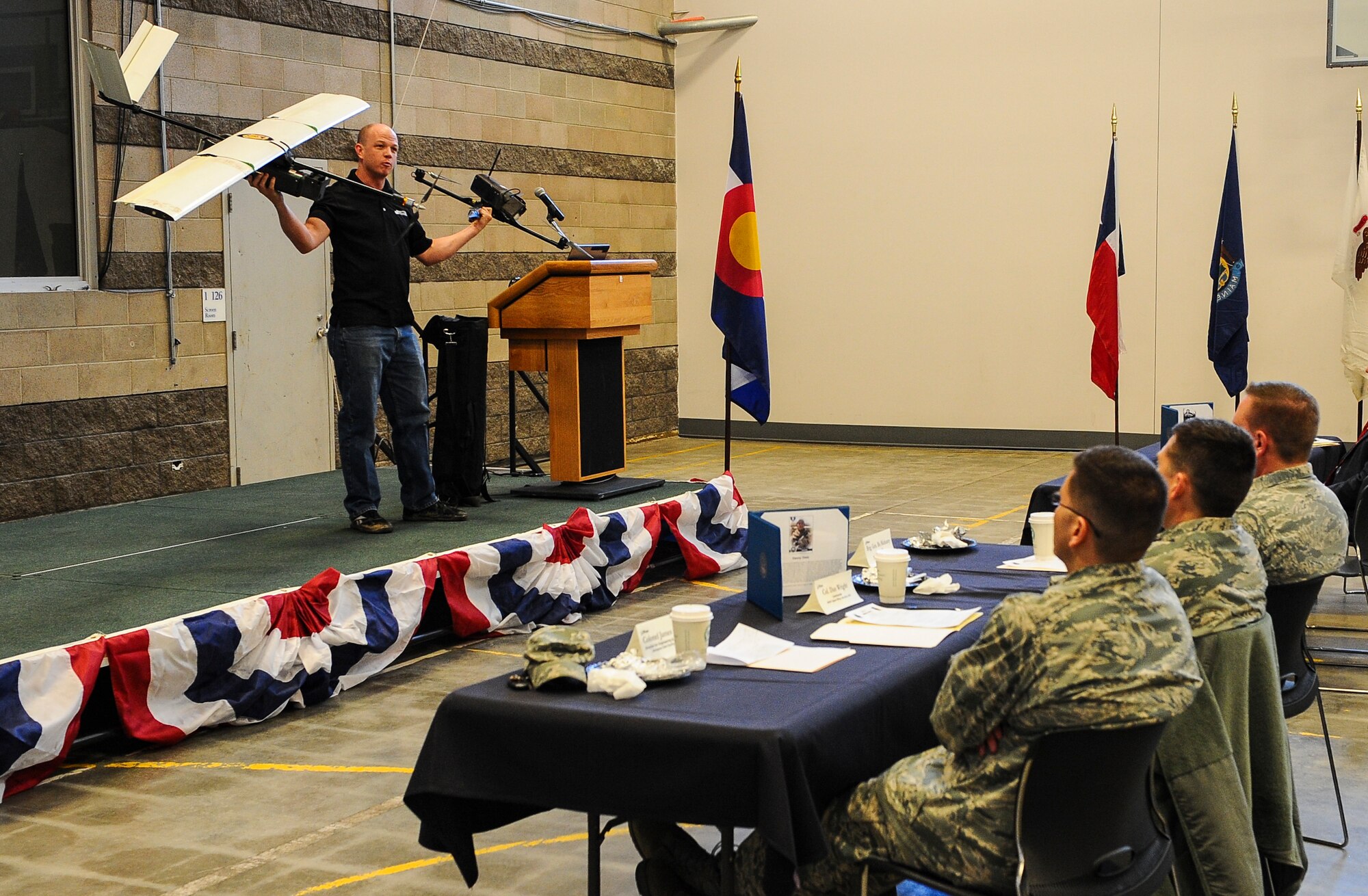Chris Miser, Falcon UAV principal, explains the uses of unmanned aerial vehicle at the monthly Aurora Defense Council meeting Feb. 27, 2014, at the Navy Operational Support Center Denver facility on Buckley Air Force Base, Colo.  The meeting included a briefing from base partner commanders, local and state organizations, and an UAV demonstration by Falcon UAV. (U.S. Air Force photo by Senior Airman Phillip Houk/Released)  