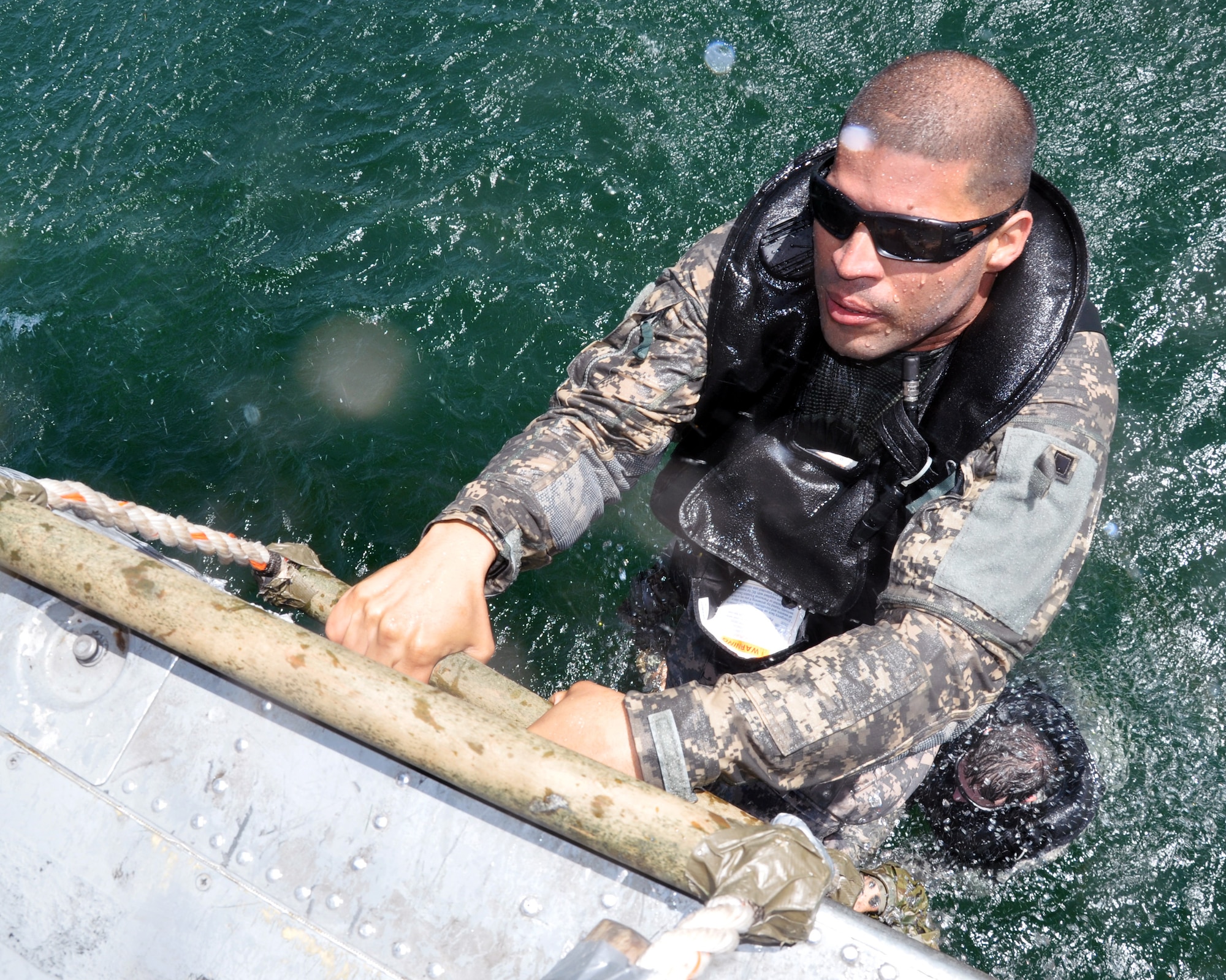 Members of Joint Task Force-Bravo climb a caving ladder attached to a UH-60 Blackhawk helicopter during a training exercise at Lake Yojoa, Honduras, Feb. 25, 2014. Task Force members and members of the 7th Special Forces Group (Airborne) conducted helocast, caving ladder and overwater hoist training during the exercise in order to maintain proficiency in a variety of skill sets as well as to prepare for future operations and exercises throughout Central America. (U.S. Air Force photo by Capt. Zach Anderson)