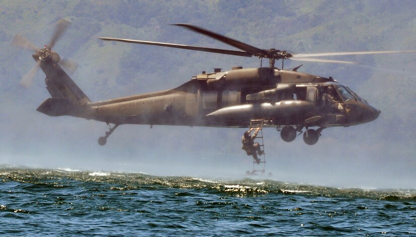 Members of Joint Task Force-Bravo climb a caving ladder attached to a UH-60 Blackhawk helicopter during a training exercise at Lake Yojoa, Honduras, Feb. 25, 2014. Task Force members and members of the 7th Special Forces Group (Airborne) conducted helocast, caving ladder and overwater hoist training during the exercise in order to maintain proficiency in a variety of skill sets as well as to prepare for future operations and exercises throughout Central America. (U.S. Air Force photo by Capt. Zach Anderson)