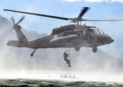 Members of Joint Task Force-Bravo climb a caving ladder attached to a UH-60 Blackhawk helicopter during a training exercise at Lake Yojoa, Honduras, Feb. 25, 2014. Task Force members and members of the 7th Special Forces Group (Airborne) conducted helocast, caving ladder and overwater hoist training during the exercise in order to maintain proficiency in a variety of skill sets as well as to prepare for future operations and exercises throughout Central America. (U.S. Air Force photo by Capt. Zach Anderson)