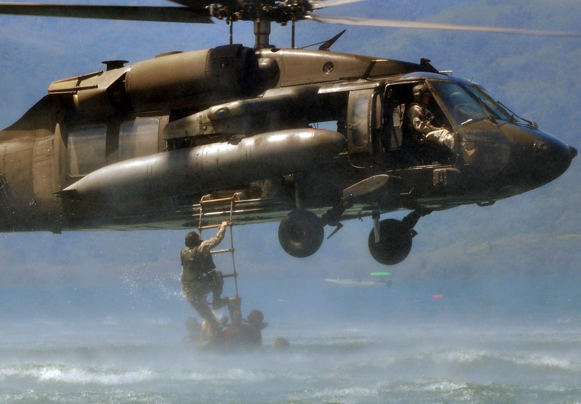 Members of Joint Task Force-Bravo climb a caving ladder attached to a UH-60 Blackhawk helicopter during a training exercise at Lake Yojoa, Honduras, Feb. 25, 2014. Task Force members and members of the 7th Special Forces Group (Airborne) conducted helocast, caving ladder and overwater hoist training during the exercise in order to maintain proficiency in a variety of skill sets as well as to prepare for future operations and exercises throughout Central America. (U.S. Air Force photo by Capt. Zach Anderson)