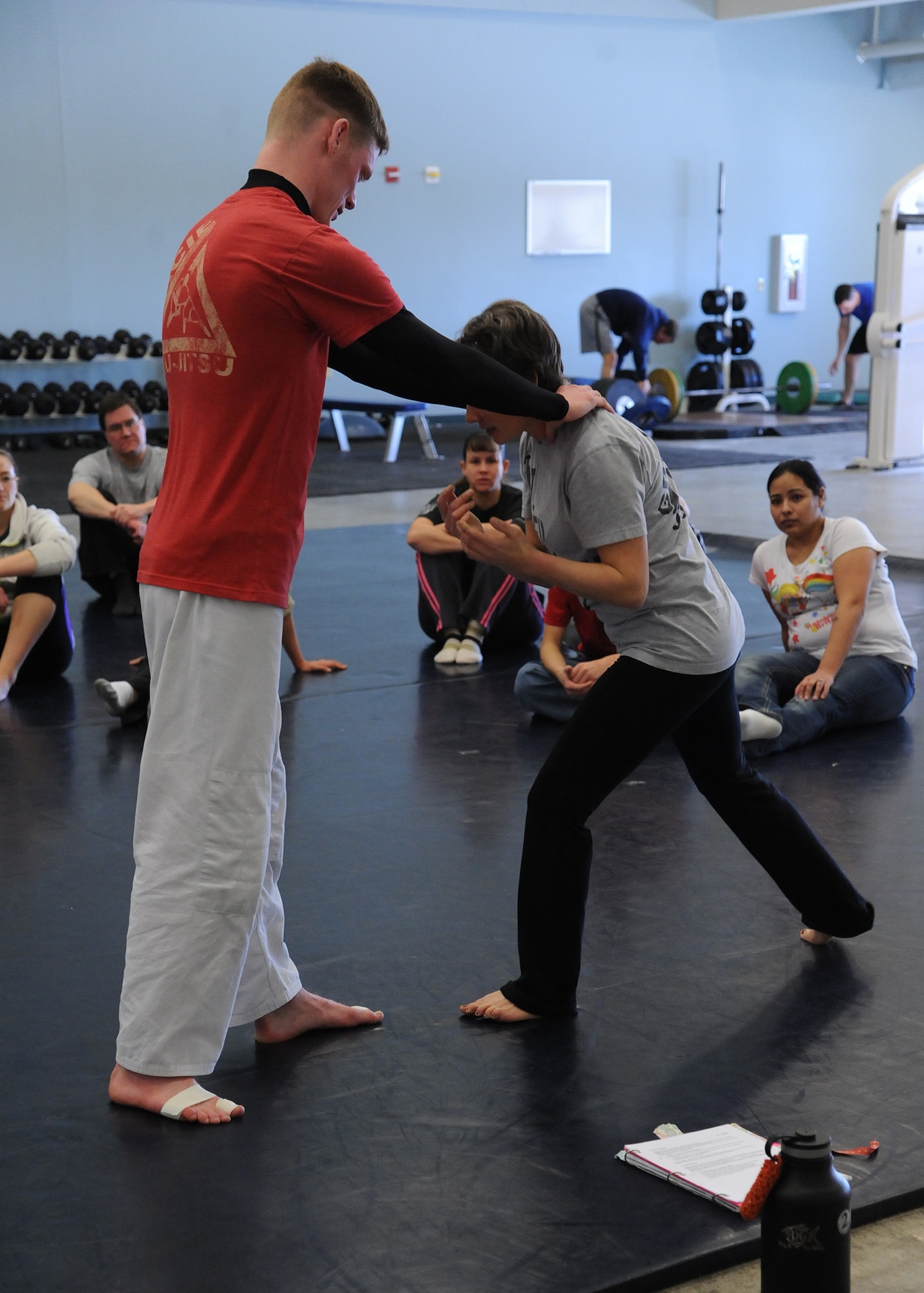 Tina Steffen, Malmstrom dependent (right), and Senior Airman Tory Satterfield, 341st Missile Security Forces Squadron member, show class participants the proper way to escape a front-choke scenario. Steffen and Satterfield, as well as a few other Team Malmstrom members, are certified to teach the Gracie Defense System course. (U.S. Air Force photo/Senior Airman Cortney Paxton) 