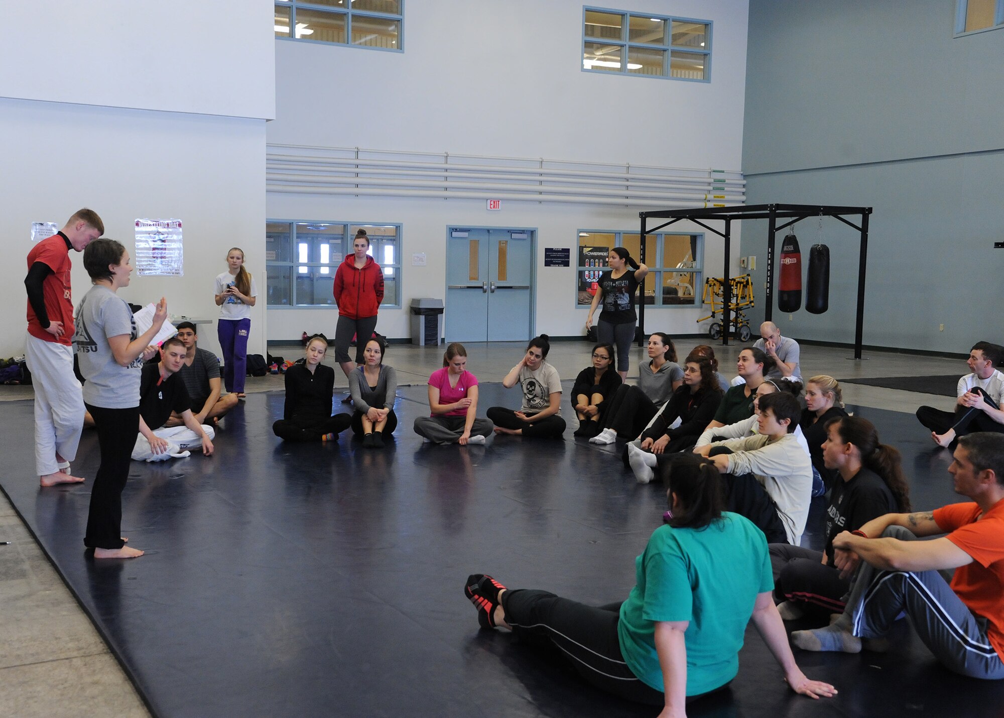 Gracie Defense Systems pink-belt certified instructors speak to participants about the importance of awareness during a self-defense seminar at the base fitness center Feb. 22. The GDS course will be offered by certified instructors to anyone with access to base every Tuesday and Saturday starting March 1. (U.S. Air Force photo/Senior Airman Cortney Paxton)