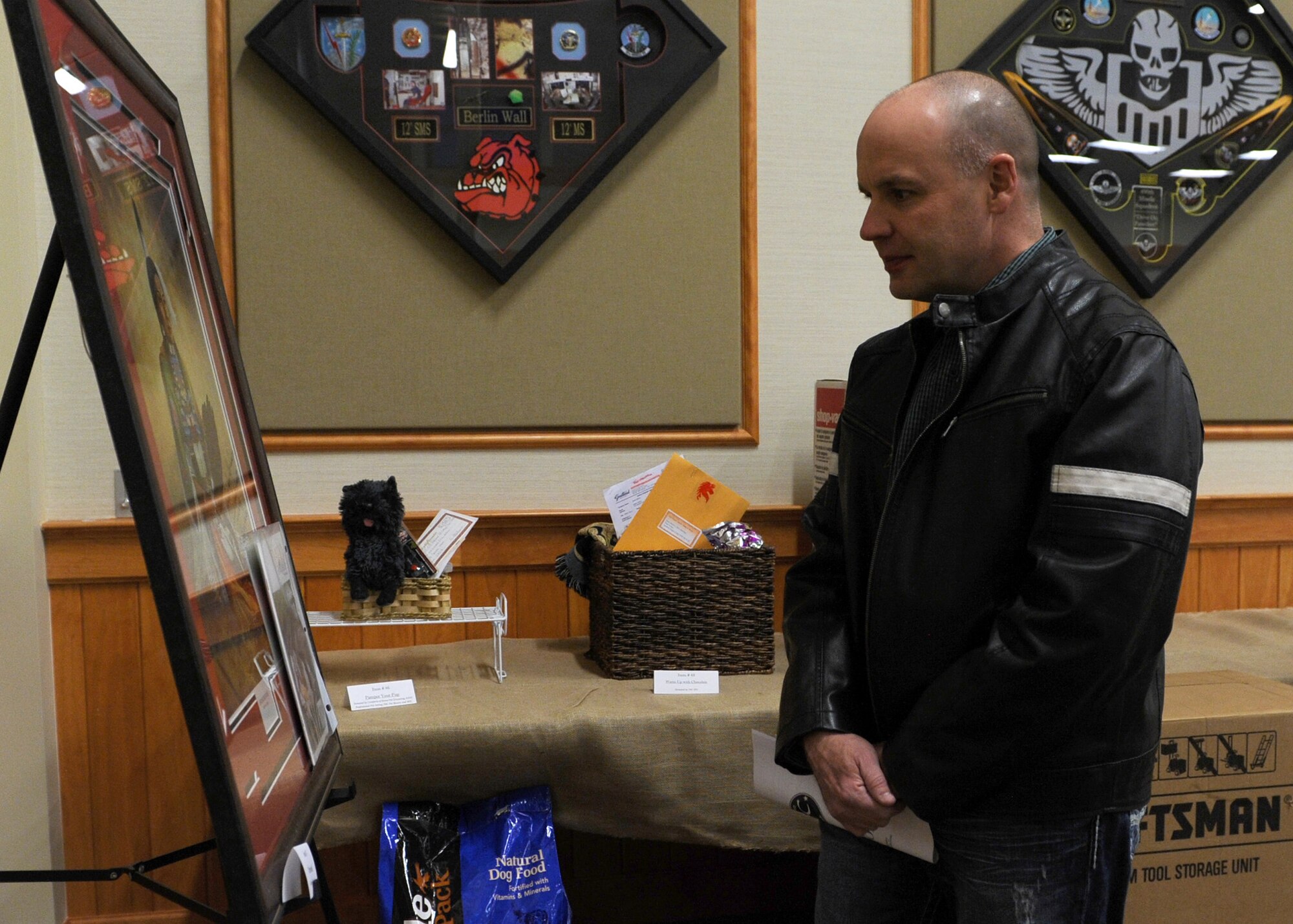 Chaplain (Lt. Col.) Mark Roberts, 341st Missile Wing chaplain, views a painting during the annual Mercantile Auction, hosted by the Malmstrom Spouses’ Club at the Grizzly Bend on Feb. 22. This year marked the 25th anniversary of the event, which auctioned off 90 items. (U.S. Air Force photo/Senior Airman Katrina Heikkinen)