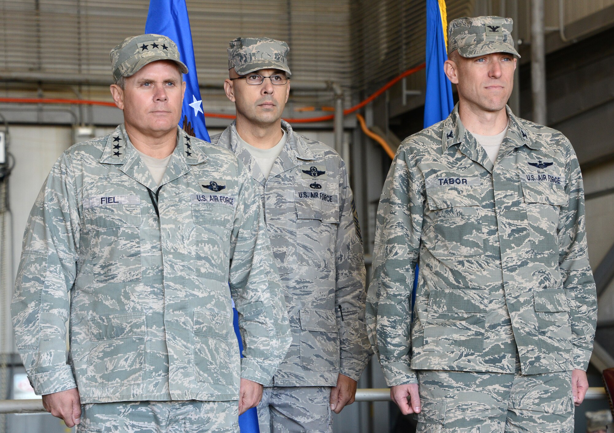 Lt. Gen. Eric Fiel, Air Force Special Operations Command commander, and Col. David Tabor stand at attention for the symbolic passing of the flag held by Command Chief Master Sgt. Michael Klausutis, giving Tabor command of the Air Force Special Operations Air Warfare Center at a ceremony at Duke Field, Fla., Feb. 27, 2014. Tabor took command of AFSOAWC which is responsible for doctrine development, education, training and execution of the command's irregular warfare capabilities. (U.S. Air Force photo by Master Sgt. Steven Pearsall) 