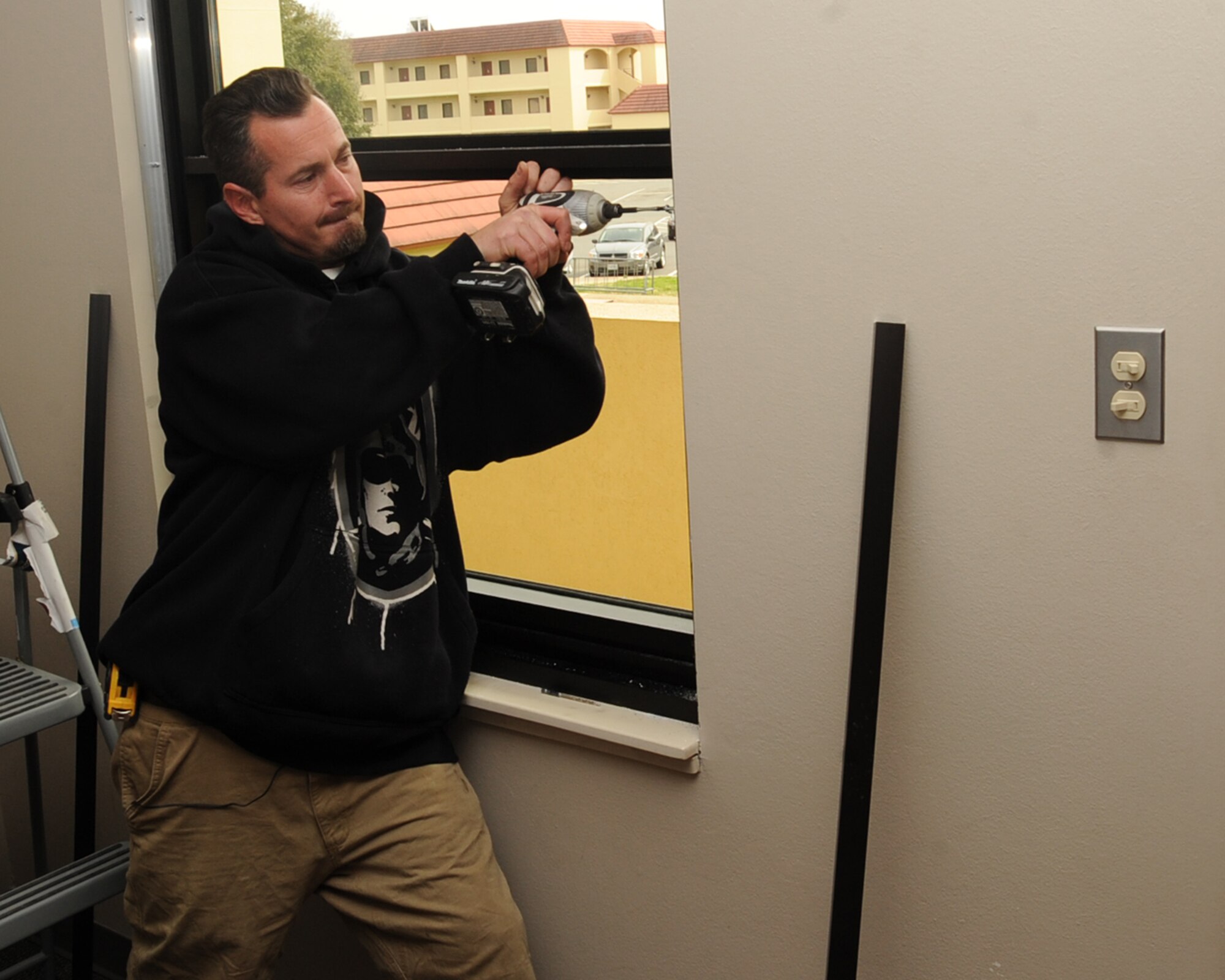 Thomas Sapling, local contractor, drills holes to install an explosion proof window in a dormitory on Barksdale Air Force Base, La., Feb. 25, 2014. The windows are being installed as a way to cut down on energy rates. (U.S. Air Force photo/Staff Sgt. Sean Martin)

