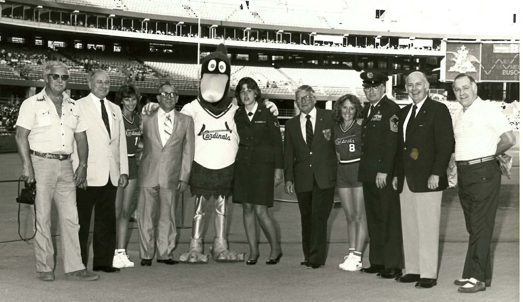 Fredbird, the St. Louis Cardinals mascot, and two of the Cardinals bat girls gather for a group photo at Air Force Association night at Busch Stadium in St. Louis in July 1982. Other known individuals in the photo include Judge John Brosky, AFA president from 1981-82, second from left; Staff Sgt. Annette Ware (Crawford), next to the mascot; Hugh Enyart, local AFA chapter president, fifth from right; Chief Master Sgt. of the Air Force Arthur L. “Bud” Andrews, third from right; and retired Air Force Gen. Russell Dougherty. (U.S. Air Force photo)
   
