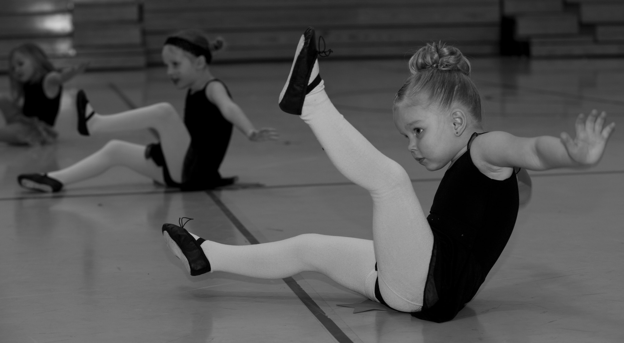Sadie Wilcox, daughter of Airman 1st Class Joshua Wilcox, 849th Aircraft Maintenance Squadron, stretches with her classmates during jazz class at Holloman Air Force Base, N.M., Youth and Teen Center Feb. 25. The DS Dance Academy directed by Rebecca Hulun holds dance classes in the Youth and Teen center gymnasium. The academy offers a variety of dance classes for students ages toddler to 12 years old. (U.S. Air Force photo by Airman 1st Class Leah Ferrante/Released) 