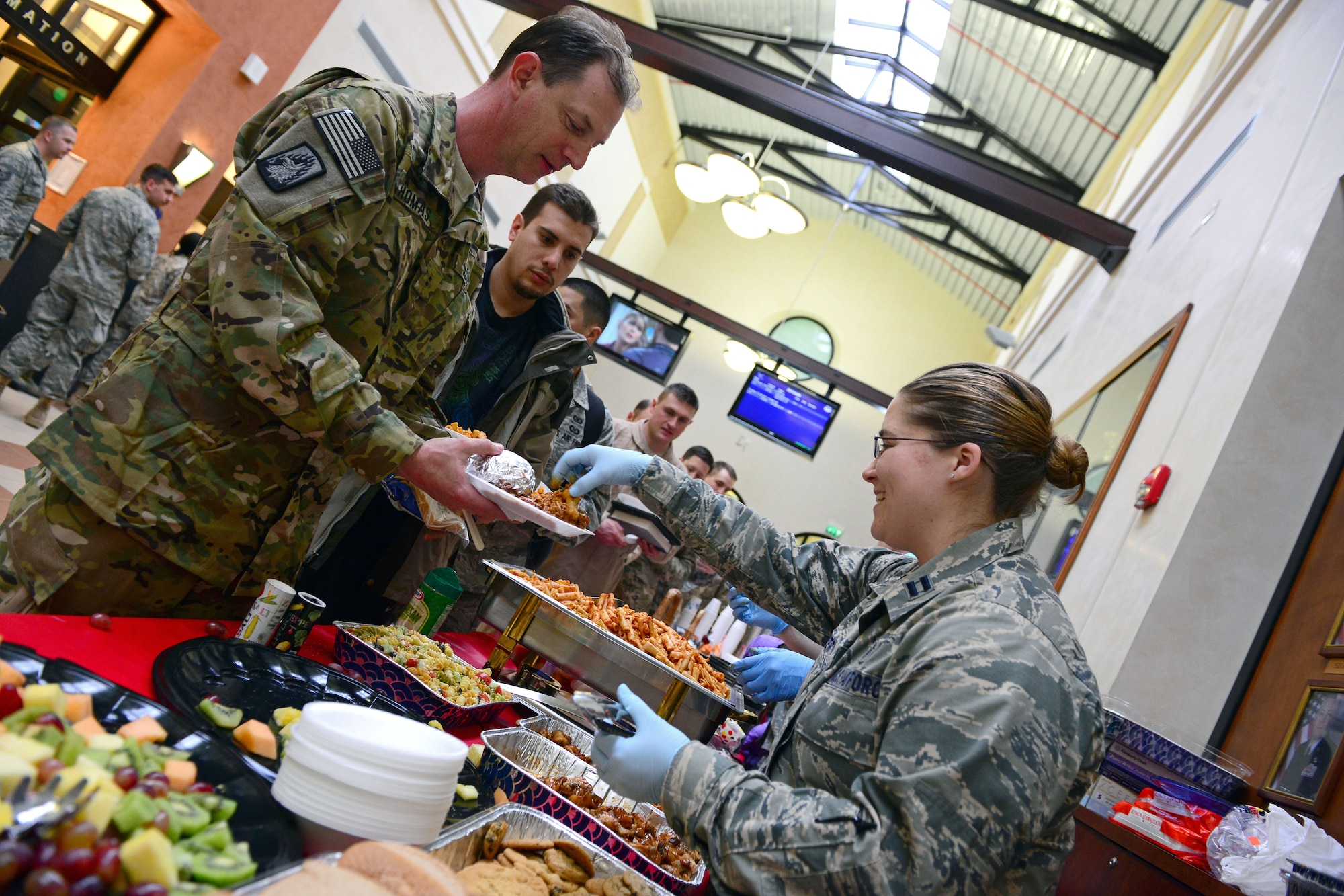 Capt. Julie Glover, Operation Yellow Ribbon volunteer, serves food to deploying service members , Feb. 26, 2014, at Aviano Air Base, Italy. The volunteers devoted their time twice a week for flights with more than 200 military members arriving at the Aviano Passenger Terminal. (U.S. Air Force photo/Senior Airman Matthew Lotz)