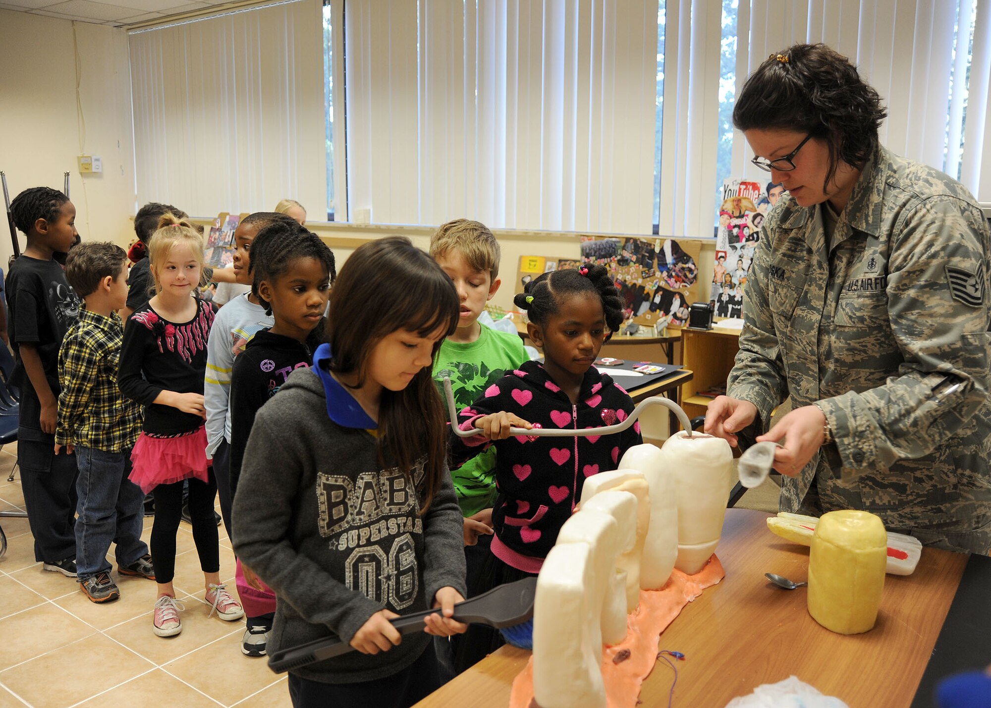INCIRLIK AIR BASE, Turkey—Tech. Sgt. Elizabeth Loska, 39th Medical Group NCO in charge of preventive dentistry, uses a  dental training module to provides a hands-on demonstration of dentistry tools to educate students at the Incirlik Unit School Feb. 26, 2014, Incirlik Air Base, Turkey. February is National Children’s Dental Health Month, during this month Airmen from the 39th Medical Group Dental Clinic provided oral health education to students in kindergarten through fifth grade. Airmen from the Dental Clinic also provided 39 exams to children during the “Little Teeth, Big Smiles” clinic held on base. (U.S. Air Force photo by Staff Sgt. Veronica Pierce/Released)                           
