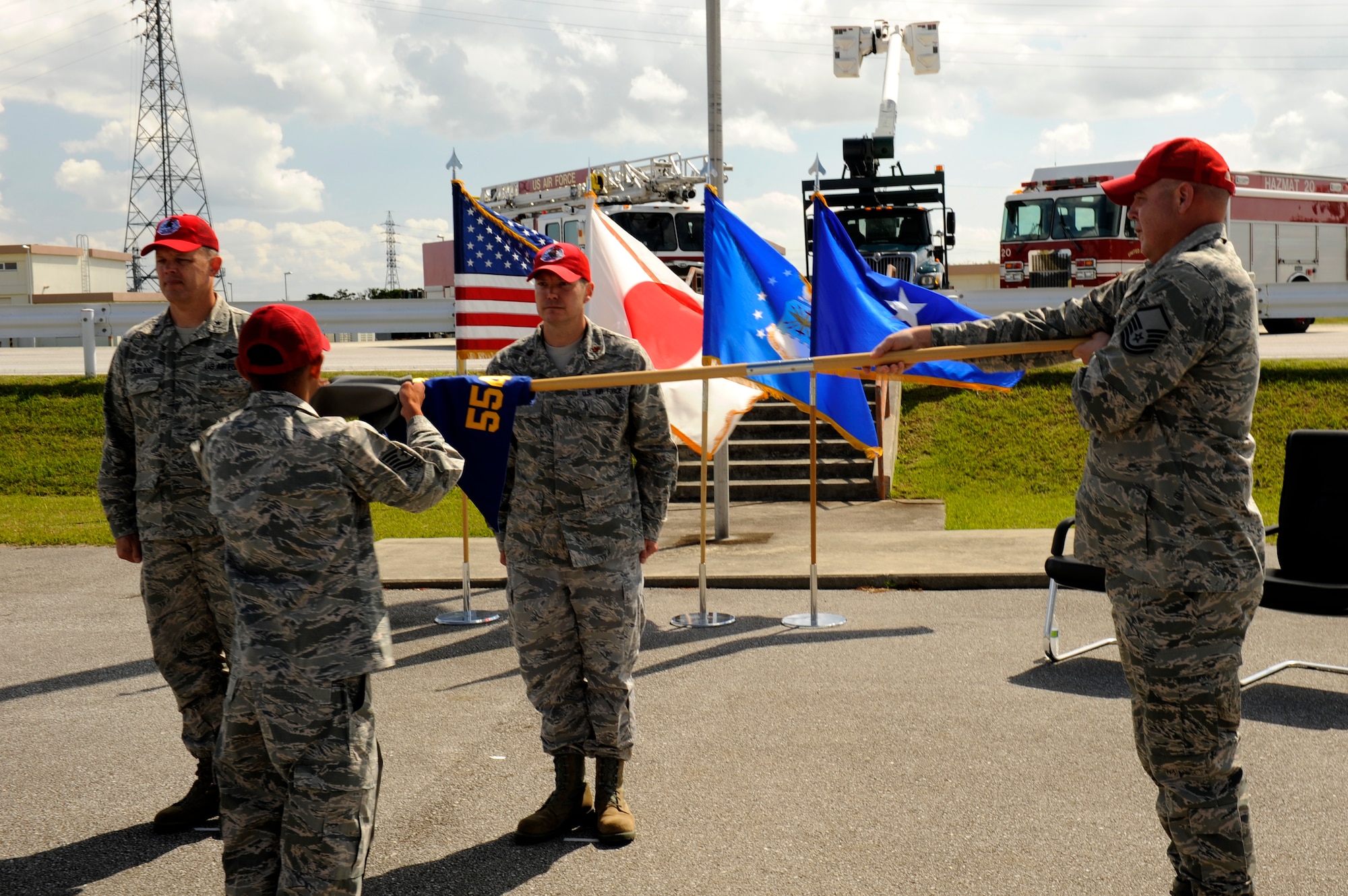 U.S. Air Force Tech. Sgt. Marlon Quitos, Detachment 1, 554th RED HORSE Squadron electrical systems contingency training instructor (center), sheaths the Detachment 1 guidon during the Silver Flag Stand Down Ceremony on Kadena Air Base, Japan, Feb. 21, 2014. The Silver Flag site has remained at Kadena since 1987, and will move to Anderson Air Force Base, Guam following the stand down. (U.S. Air Force photo by Senior Airman Maeson L. Elleman)