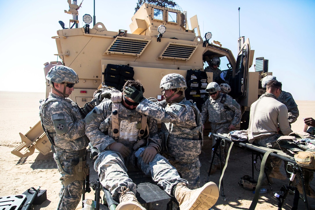 U.S. Army medics provide medical aid to U.S. Army Pfc. Pomeroy, center ...