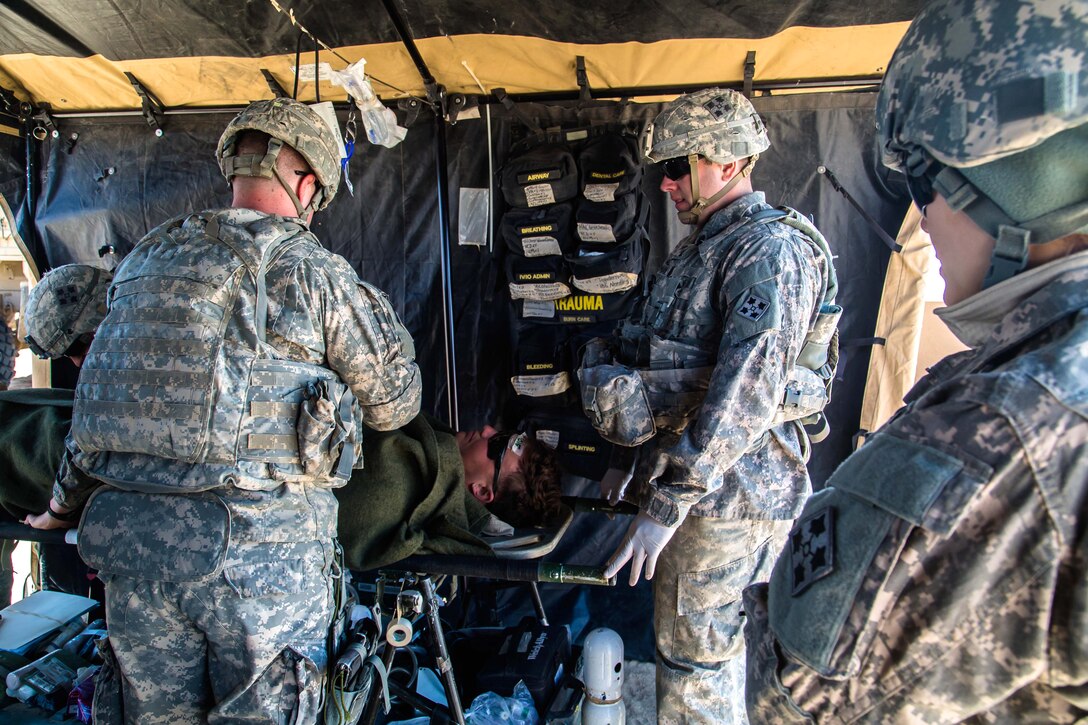 U.S. Army medics provide medical aid to U.S. Army Pfc. Pomeroy, center ...