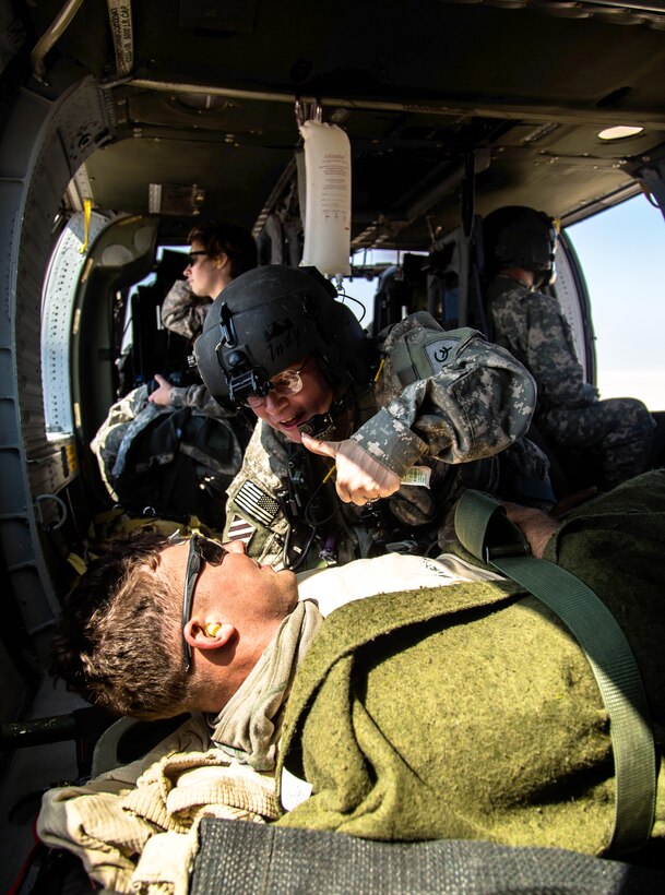 U.S. Army Sgt. 1st Class Dana Howard, back, reassures U.S. Army Pfc. Pomeroy as part of an air medical evacuation exercise during Operation Intrepid Centurion near Camp Buehring, Kuwait, Feb. 19, 2014. Howard, a combat medic, is assigned to Company C, 2nd Battalion, 238th Air Ambulance, 42nd Combat Aviation Brigade, and Pomeroy, an infantryman, is assigned to 4th Infantry Division's 67th Armored Regiment, 2nd Brigade.