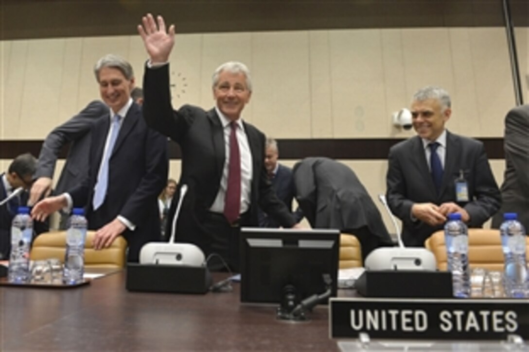 U.S. Defense Secretary Chuck Hagel waves to other meeting attendees at the beginning of the non-NATO International Security Assistance Force contributing nations meeting in Brussels, Feb. 27, 2014.