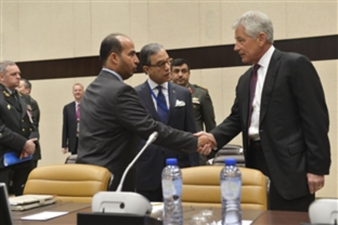 U.S. Defense Secretary Chuck Hagel, right, greets representatives from other nations during a meeting of the non-NATO International Security Assistance Force contributing nations on the final day of NATO defense ministerial meetings in Brussels, Feb. 27, 2014.