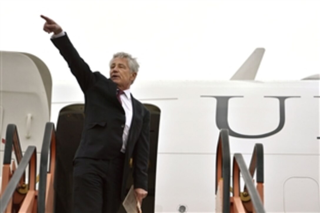 U.S. Defense Secretary Chuck Hagel waves as he boards his aircraft shortly after the conclusion of the NATO defense ministerial meetings in Brussels, Feb. 27, 2014.