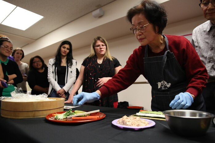 Michiyo Okazaki, a Japanese volunteer, demonstrates how to make Norimaki during a sushi making class hosted by the Marauders Spouse Club, Feb. 22, 2014, aboard Marine Corps Air Station Iwakuni, Japan. The Marauders Spouse Club offered the class to spouses and guests from all units aboard station.