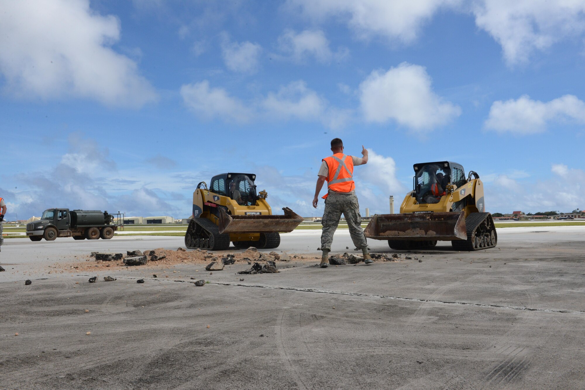 Staff Sgt. Austin Winegardner directs Airmen operating heavy machinery to clear debris away from a simulated damaged area created during airfield damage repair training Jan. 23, 2014, at Andersen Air Force Base, Guam. The 36th Civil Engineer Squadron was one of the first units in the Air Force to receive training on a new airfield damage repair capability. Winegardner is a project leader with the 36th Civil Engineer Squadron. (U.S. Air Force photo/Airman 1st Class Emily A. Bradley) 
