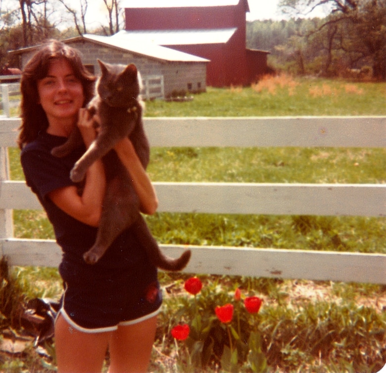University of Virginia freshman, Betty Grey Waring, dotes on her family cat, Bleu, while home on their 500-acre grain farm in Tappahannock, Va. "Pets were important to our family, both dogs and cats," said Anne Frost Waring, sister of Betty Grey Waring." "But cats were and still are our 'soul mates'. When we were growing up, our cat 'Tippy,' who was white with black spots, had numerous litters of kittens. We found homes for every one of them. We also played 'dress up' and put those poor kittens in our pocketbooks, hanging out of the end for dear life. One of our favorite kittens was a striped tabby whom we named Tommy. We just adored him. When he was given to a cousin who lived down the road, a big discovery was made. Tommy was a girl and had to undergo a name change." Anne Frost Waring is a communications manager for the Virginia Commonwealth's Department of Human Resource Management.