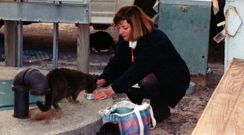 Betty Grey Waring, volunteer member of the Norfolk District Feral Cat Management Program, feeds Blackie. Norfolk District's all-volunteer program was established in 1992 to act as caretakers for the cats, which at the height of the program numbered 60, with a few strays.