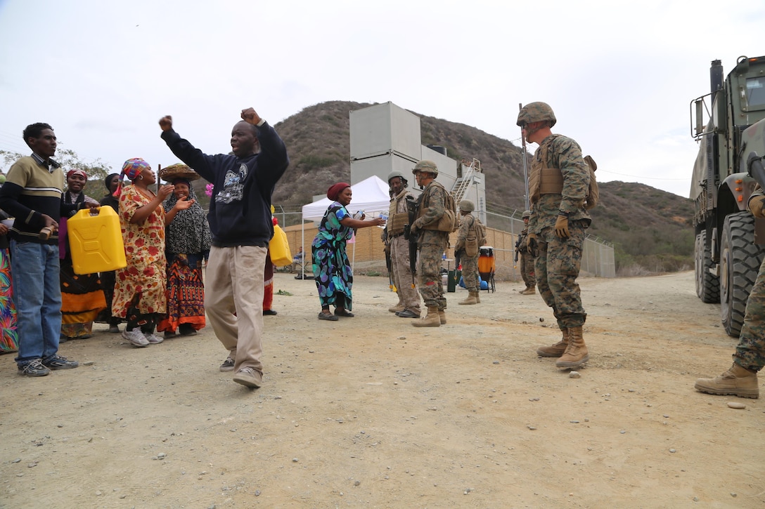 Marines with Combat Logistics Battalion 11, 11th Marine Expeditionary Unit stand fast as locals protest as part of a re-supply training scenario here Feb. 26. The mission for the training event was to equip a foreign town with food and water supplies. Part of the training tested Marines’ ability to maintain their composure while accomplishing the mission. The Marines also used a local national who was dressed in a Marine Corps combat utility uniform and personal protective equipment as an interpreter.   