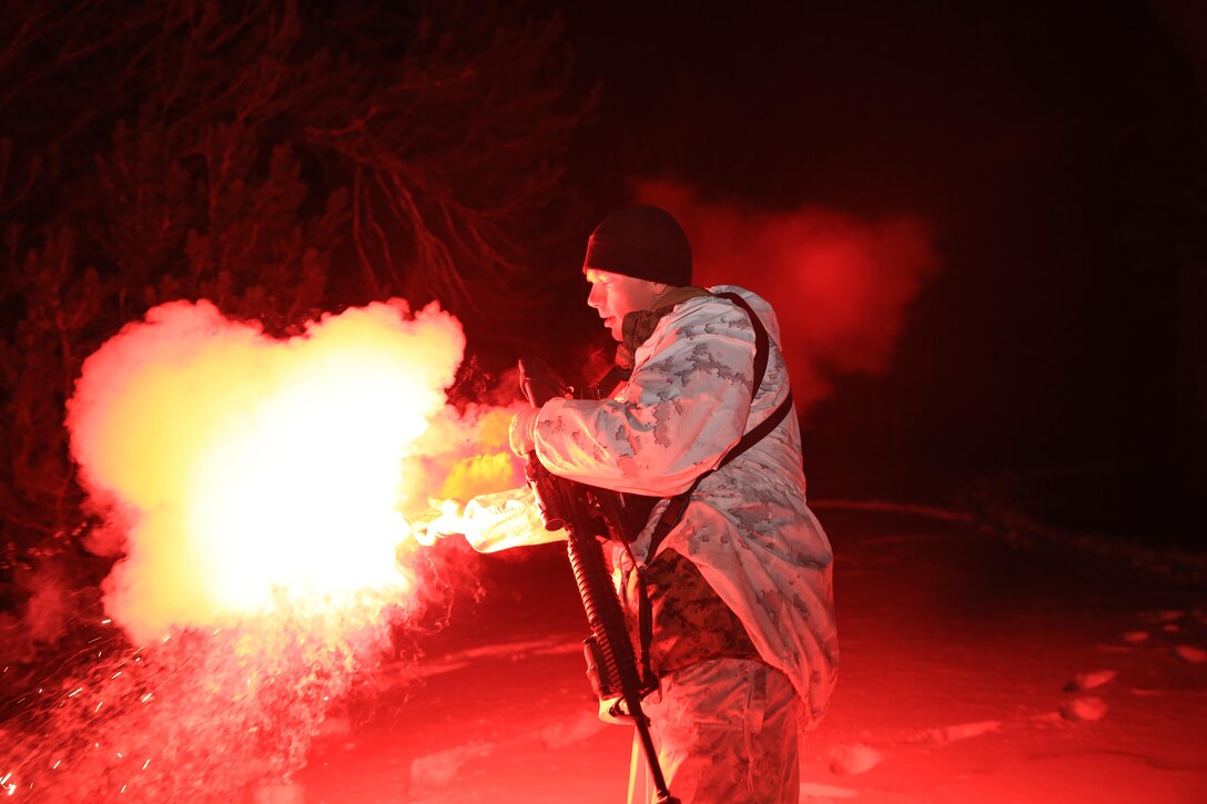 Sgt. Dylan Hulbert, mountain leader instructor, Marine Corps Mountain Warfare Training Center, lights a flare signaling the end of the advance toward a simulated enemy camp during a long-range movement exercise aboard the training center, Feb. 20, 2014. The exercise was a three-day event and focused on traveling long distances and employing combat tactics at night.
