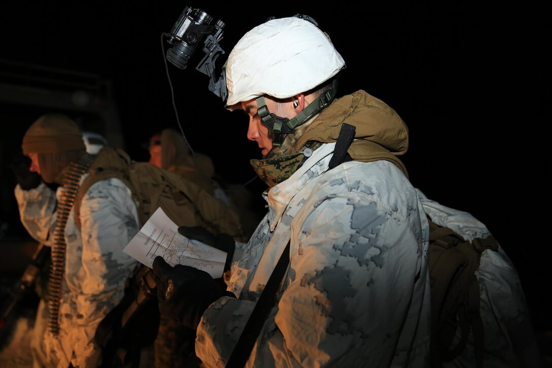 Sgt. Eric Masters, mountain leader instructor, Marine Corps Mountain Warfare Training Center, looks at a map with different routes to take toward a simulated enemy camp aboard the training center, Feb. 20, 2014. The training area where the exercise was conducted is approximately 8000 feet in elevation.