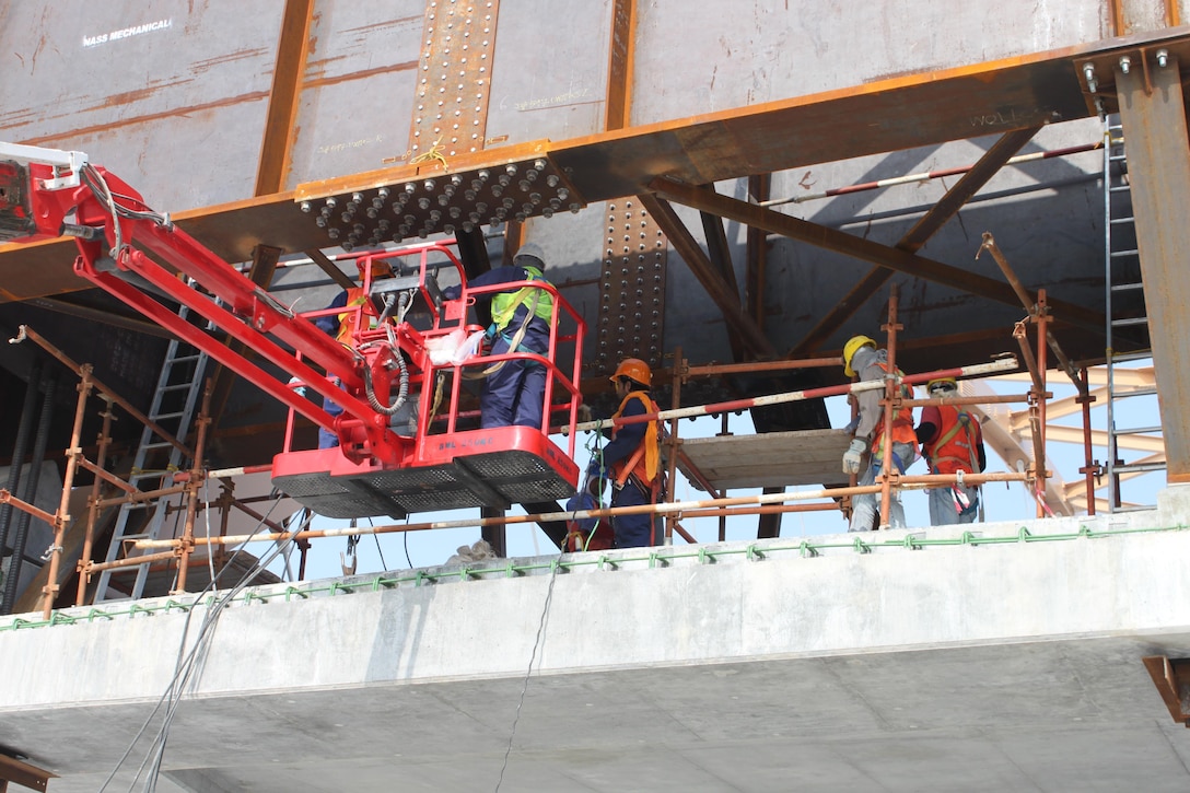 Crews work to prepare to move the bridge across the causeway into its final position.